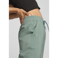 Damskie spodnie LACE PUMA Green Moon. Zielone spodnie sportowe Puma, bez wzorów, na jogę i pilates. W wyprzedaży za 214.20 zł.
