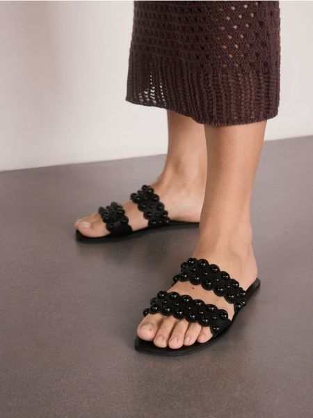 Klapki z okuciami - czarny. Czarne klapki Reserved, bez wzorów, z materiału, bez obcasa, bez zapięcia. W wyprzedaży za 45.99 zł.