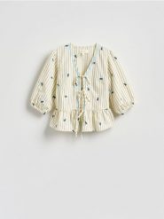 Bluzka z kwiatowym wzorem - złamana biel. Bluzki Reserved, l, bez wzorów, z tkaniny, bez kołnierzyka, bez ramiączek. Za 179.99 zł.