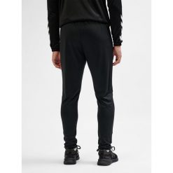 SPODNIE hmlESSENTIAL TRAINING PANTS. Czarne spodnie dresowe Hummel, bez wzorów, z dresówki. Za 100.00 zł.