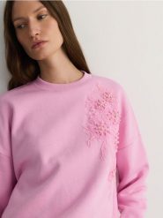 Bawełniana bluza z aplikacją - pastelowy róż. Czerwone bluzy Reserved, l, z aplikacjami, z bawełny, bez ramiączek, bez kaptura. W wyprzedaży za 79.99 zł.