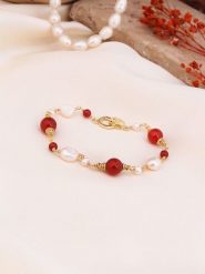 Pierres de Jade Pozłacana bransoletka z perłami i koralami rozmiar: onesize. Białe bransoletki Pierres de Jade, z koralem, pozłacane. Za 43.99 zł.