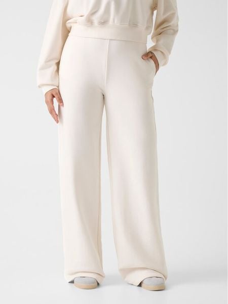 Guess Spodnie dresowe V6RB03 KD761 Kremowy Wide Leg. Białe spodnie dresowe Guess, z aplikacjami, z bawełny. Za 179.99 zł.