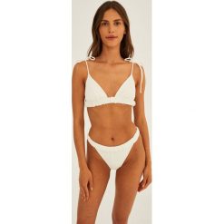 Undress Code biustonosz kąpielowy kolor biały lekko usztywniona miseczka. Białe bikini Undress Code, bez wzorów. W wyprzedaży za 234.99 zł.