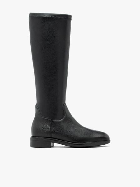 Czarne kozaki z elastyczną cholewką. Czarne kozaki Brawo sp. z o.o., bez wzorów, ze skóry, eleganckie, bez obcasa, na płaskiej podeszwie, bez zapięcia. Za 499.99 zł.