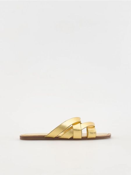 Skórzane klapki z metalicznym efektem - złoty. Żółte klapki Reserved, bez wzorów, ze skóry, bez obcasa, bez zapięcia. W wyprzedaży za 69.99 zł.