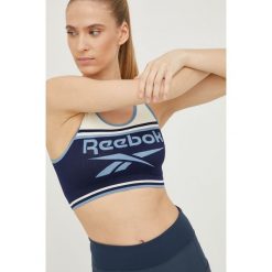 Reebok biustonosz sportowy Kerys kolor granatowy wzorzysty. Niebieskie biustonosze sportowe Reebok, bez wzorów, z materiału, na jogę i pilates. Za 119.99 zł.