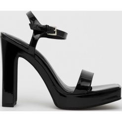 Dkny sandały Maiden kolor czarny. Czarne sandały DKNY, bez wzorów, z materiału, bez obcasa, na obcasie, bez zapięcia. W wyprzedaży za 449.99 zł.