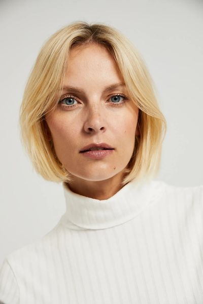 Prążkowany golf z ozdobymi guzikami na rękawach biały. Białe swetry MOODO, m, bez wzorów, z bawełny, bez ramiączek. W wyprzedaży za 30.99 zł.