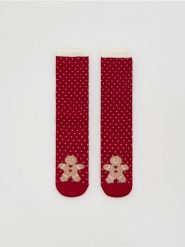 Skarpetki ze świątecznym motywem - czerwony. Czerwone skarpetki Reserved, bez wzorów. Za 29.99 zł.