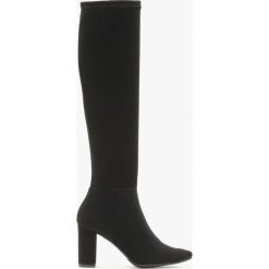 Wysokie kozaki z elastyczną cholewką PORTIA. Czarne kozaki Ryłko, bez wzorów, z nubiku, z okrągłym noskiem, bez obcasa, na obcasie, bez zapięcia. Za 349.99 zł.