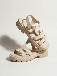 Sandały z imitacji skóry na platformie - kremowy. Białe sandały Sinsay, bez wzorów, ze skóry, bez obcasa, na platformie, bez zapięcia. Za 59.99 zł.