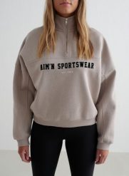 Damska bluza dresowa z półzamkiem, drapana, luźna Varsity ciemna glina. Brązowe bluzy bez kaptura AIM'N, xl, bez wzorów, z bawełny, bez kaptura, na fitness i siłownię. Za 339.00 zł.