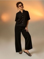 Klapki z motywem zebry ze skórzaną wkładką - czarny. Czarne klapki Sinsay, bez wzorów, bez obcasa, bez zapięcia. Za 49.99 zł.