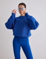 Damska bluza biegowa oddychająca, odprowadzająca wilgoć Le Run błękitna. Niebieskie bluzy AIM'N, s, bez wzorów, z bawełny, bez kaptura, na fitness i siłownię. Za 381.00 zł.
