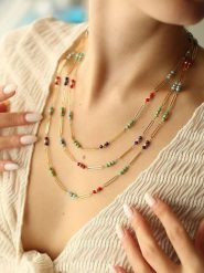 Pierres de Jade Pozłacany naszyjnik z elementami ozdobnymi - dł. 50 cm rozmiar: onesize. Żółte naszyjniki Pierres de Jade, z materiału, z kryształem, pozłacane. Za 93.07 zł.