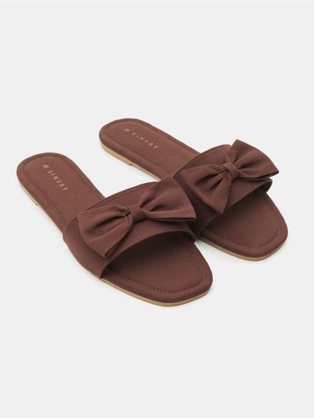 Klapki z kokardą - brązowy. Brązowe klapki Sinsay, bez wzorów, bez obcasa, bez zapięcia. Za 29.99 zł.