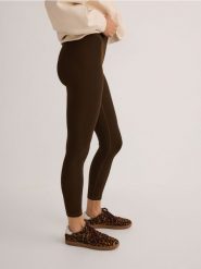 Gładkie legginsy - brązowy. Brązowe legginsy Reserved, bez wzorów, z dzianiny. W wyprzedaży za 49.99 zł.