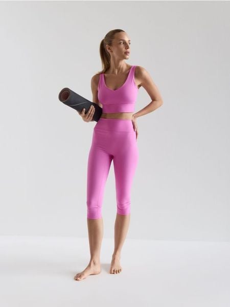 Legginsy capri - intensywny róż. Czerwone legginsy Reserved, bez wzorów, z dzianiny. Za 99.99 zł.