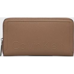 Calvin Klein portfel damski kolor brązowy. Brązowe portfele Calvin Klein, bez wzorów, z materiału. W wyprzedaży za 264.99 zł.