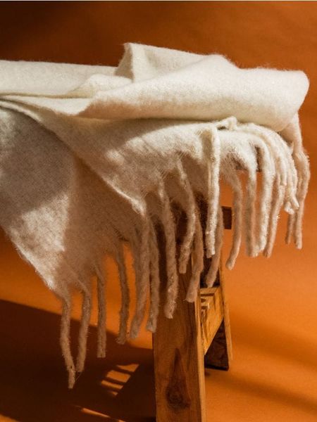 Szalik z frędzlami - kremowy. Białe chusty Sinsay, bez wzorów. Za 39.99 zł.