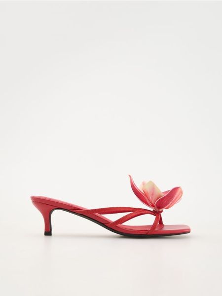 Skórzane klapki z dekoracyjnym kwiatem - czerwony. Czerwone klapki Reserved, bez wzorów, ze skóry, bez obcasa, bez zapięcia. W wyprzedaży za 79.99 zł.