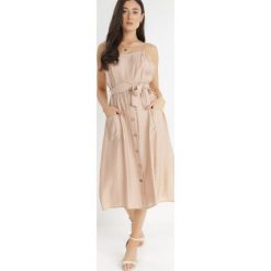 Beżowa Sukienka Sharthe. Brązowe sukienki Born2be, l, bez wzorów, z tkaniny, bez kołnierzyka, bez ramiączek, midi. Za 109.99 zł.