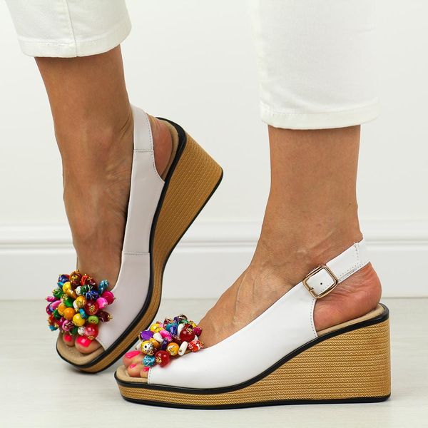 Białe skórzane sandały damskie na koturnie Filippo Ds6021/25. Białe sandały Filippo, z aplikacjami, ze skóry, eleganckie, bez obcasa, na koturnie, bez zapięcia. Za 229.00 zł.