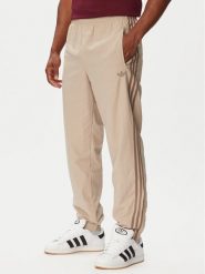 Adidas Spodnie dresowe Firebird KS7503 Beżowy Regular Fit. Brązowe spodnie dresowe adidas, bez wzorów, z dresówki. Za 299.99 zł.