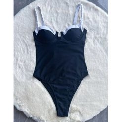Jednoczęściowy strój kąpielowy z lamówką i wbudowanym stanikiem na lato Aglaja. Czarne stroje jednoczęściowe Intica, bez wzorów, z materiału, eleganckie. Za 169.00 zł.