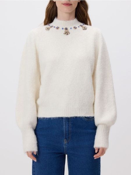 Sweter z biżuteryjną aplikacją - kremowy. Białe swetry Reserved, l, z aplikacjami, z dzianiny, bez ramiączek. Za 149.99 zł.