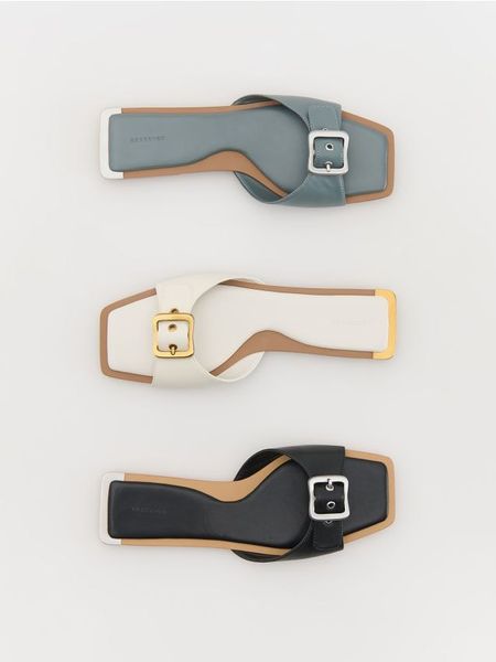 Klapki z ozdobną klamrą - czarny. Czarne klapki Reserved, bez wzorów, klasyczne, bez obcasa, bez zapięcia. W wyprzedaży za 65.99 zł.