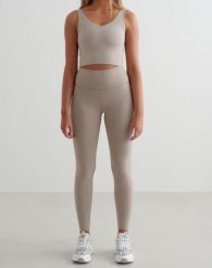 Damskie legginsy wysoki stan, odprowadzające pot, squat proof Sense Tall beżowe. Brązowe legginsy AIM'N, bez wzorów, z elastanu. Za 297.00 zł.