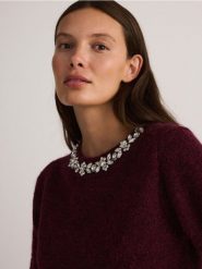 Sweter z biżuteryjną aplikacją - bordowy. Czerwone swetry Reserved, l, z aplikacjami, z dzianiny, bez ramiączek. W wyprzedaży za 119.99 zł.