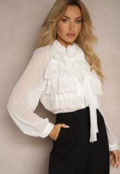 Biała Prześwitująca Koszula z Falbankami i Kwiatowym Zdobieniem przy Dekolcie Raivona. Białe koszule Renee, l, z aplikacjami, z jeansu, eleganckie, bez kołnierzyka, bez ramiączek. W wyprzedaży za 127.99 zł.