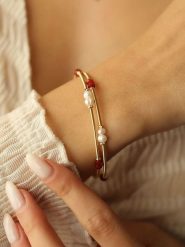 Pierres delicates Pozłacana bransoletka z kryształami i perłami rozmiar: onesize. Białe bransoletki Pierres delicates, z kryształem, pozłacane. Za 52.99 zł.