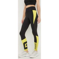 Guess legginsy damskie kolor czarny z nadrukiem. Czarne legginsy Guess, z aplikacjami, z włókna. Za 369.99 zł.