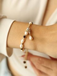 Pierres delicates Pozłacana bransoletka z kamieniami szlachetnymi i perłami rozmiar: onesize. Białe bransoletki Pierres delicates, z perłą, pozłacane. Za 52.99 zł.