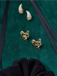 Kolczyki w kształcie kokardek - złoty. Żółte kolczyki Sinsay, złote. Za 7.99 zł.