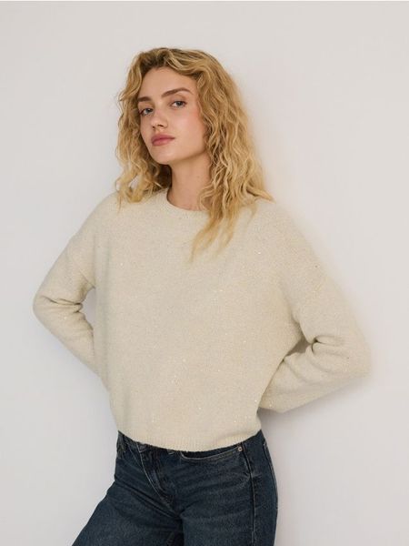 Sweter z metalizowaną nitką - kremowy. Białe swetry Reserved, l, bez wzorów, z dzianiny, bez ramiączek. W wyprzedaży za 39.99 zł.