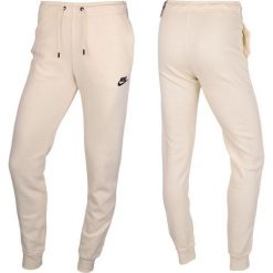 Spodnie Sportowe damskie Nike. Brązowe spodnie dresowe Nike, bez wzorów, długie. Za 240.22 zł.