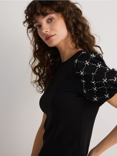 Bluzka z ozdobnymi rękawami - czarny. Czarne bluzki Reserved, l, bez wzorów, z bawełny, bez kołnierzyka, bez ramiączek. W wyprzedaży za 35.99 zł.