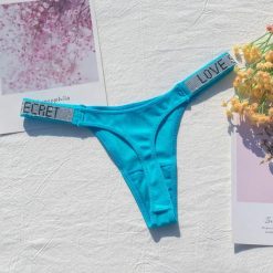 Stringi z szeroką gumką i nowoczesnym designem Dior. Czarne stringi Intica, bez wzorów, z materiału. W wyprzedaży za 79.00 zł.