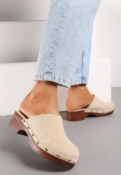 Beżowe Klapki Typu Drewniaki z Nitami i Płaskim Obcasem Nerai. Brązowe klapki Renee, z aplikacjami, z okrągłym noskiem, bez obcasa, na płaskiej podeszwie, bez zapięcia. Za 99.99 zł.