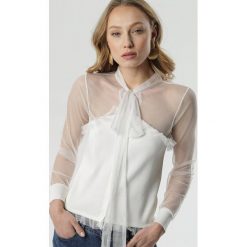 Biała Bluzka Clodagh. Białe bluzki Born2be, l, bez wzorów, z dzianiny, bez kołnierzyka, bez ramiączek. W wyprzedaży za 45.49 zł.