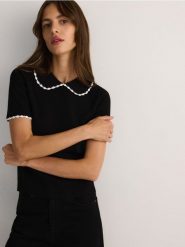 Bluzka z ozdobnym kołnierzem - czarny. Czarne bluzki Reserved, l, bez wzorów, z dzianiny, bez kołnierzyka, bez ramiączek. W wyprzedaży za 49.99 zł.