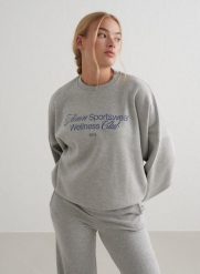 Damska bluza dresowa miękka, luźna, z okrągłym dekoltem Wellness szary melanż. Szare bluzy AIM'N, m, bez wzorów, z bawełny, bez kaptura, na fitness i siłownię. Za 339.00 zł.