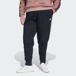 Spodnie Dresowe Essentials 3-Stripes (Dla Sylwetek Plus Size). Białe spodnie sportowe adidas, bez wzorów, z dresówki, na fitness i siłownię. Za 219.00 zł.