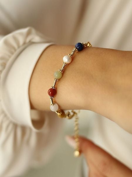 Pierres delicates Pozłacana bransoletka z kamieniami szlachetnymi i perłami rozmiar: onesize. Białe bransoletki Pierres delicates, z perłą, pozłacane. Za 52.99 zł.