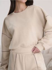 Bluza z ażurowymi detalami - kremowy. Białe bluzy Sinsay, l, w ażurowe wzory, bez kaptura, do biegania. Za 35.99 zł.